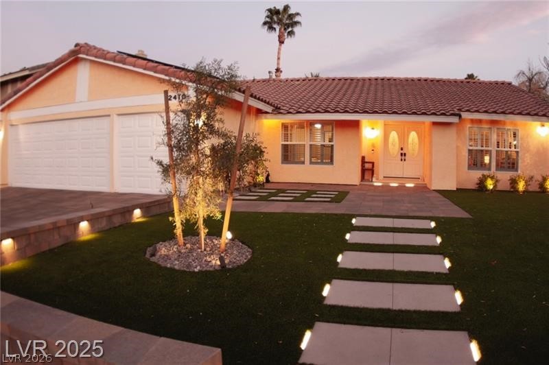 2410 Doherty Way Henderson, NV 89014 - Photo 62 of 63 View of front facade with a tile roof, an attached garage, stucco siding, and a front yard