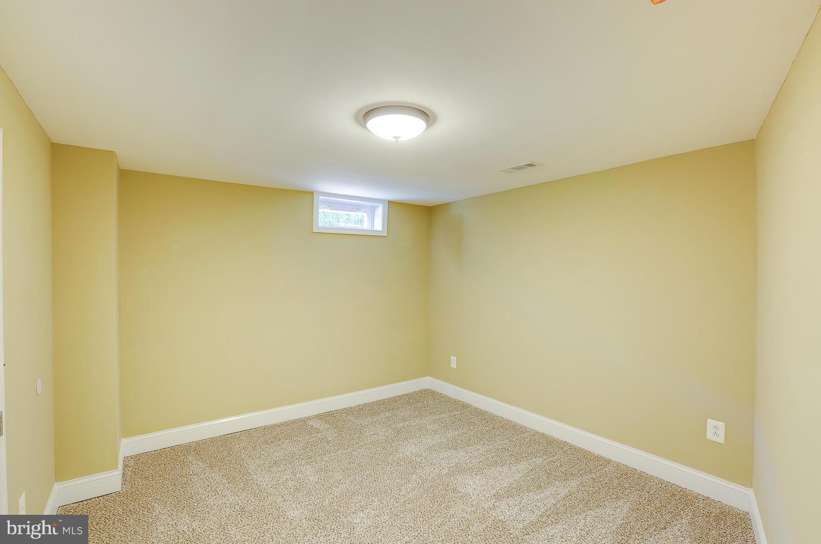 3216 Mayfair Road Baltimore, MD 21207 - Photo 18 of 24 an empty room with a wooden wall and a window