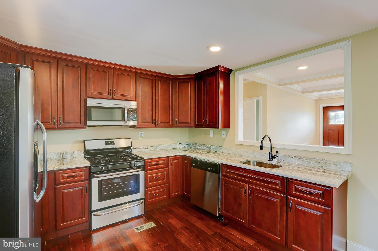 3216 Mayfair Road Baltimore, MD 21207 - Photo 9 of 24 a kitchen with stainless steel appliances granite countertop a sink stove and refrigerator