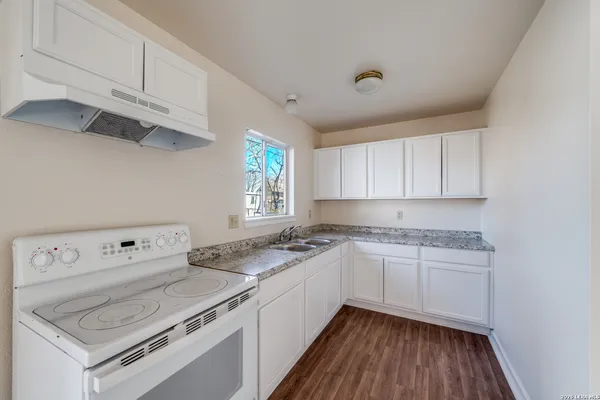 a kitchen with a stove top oven sink and cabinets