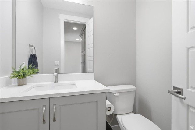 21 Pier Place Tooele, UT 84074 - Photo 29 of 112 Bathroom featuring a white quartz countertop, integrated rectangular sink, gray shaker-style vanity with chrome hardware, and a contemporary wall-mounted mirror