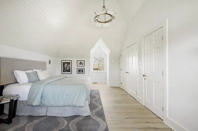 a spacious bedroom with a bed and wooden floor