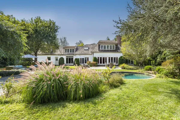 a front view of a house with swimming pool having outdoor seating