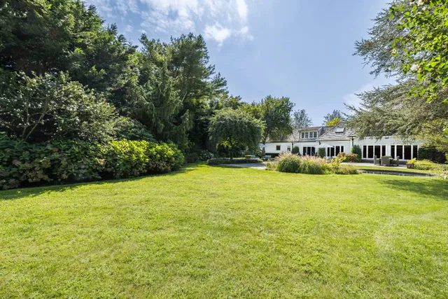 a view of a house with backyard and sitting area