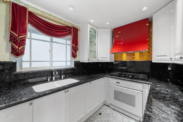 a large kitchen with stainless steel appliances granite countertop a sink and a granite counter tops