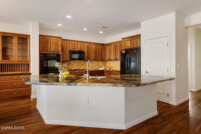 a kitchen with stainless steel appliances granite countertop a stove a refrigerator and a microwave