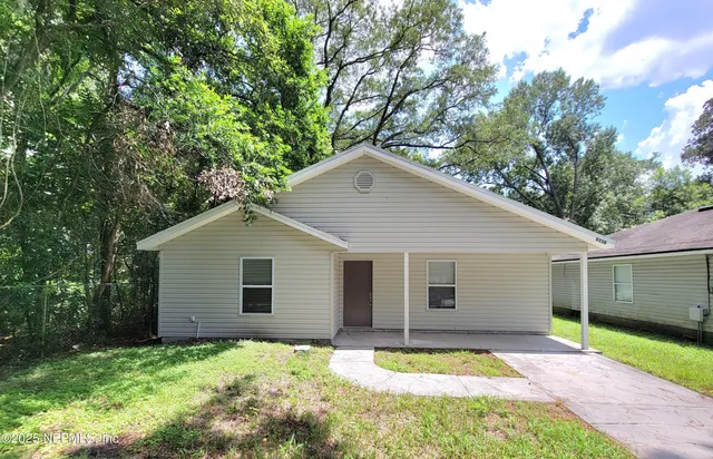 a front view of a house with a garden and yard