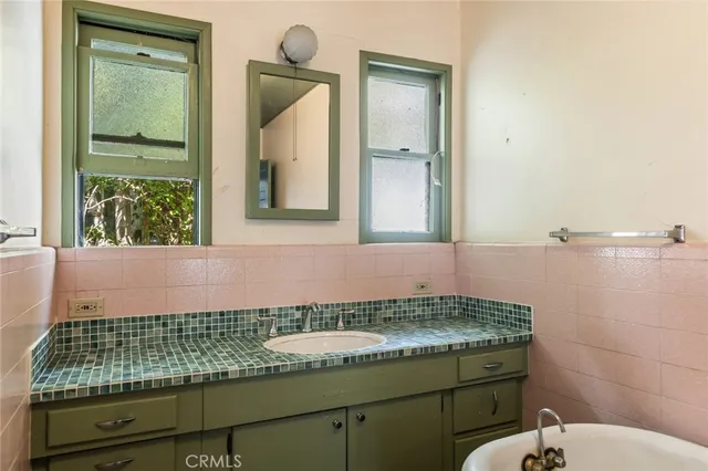 a bathroom with a granite countertop sink and a mirror