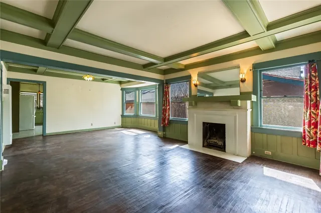 a view of empty room with wooden floor and fireplace