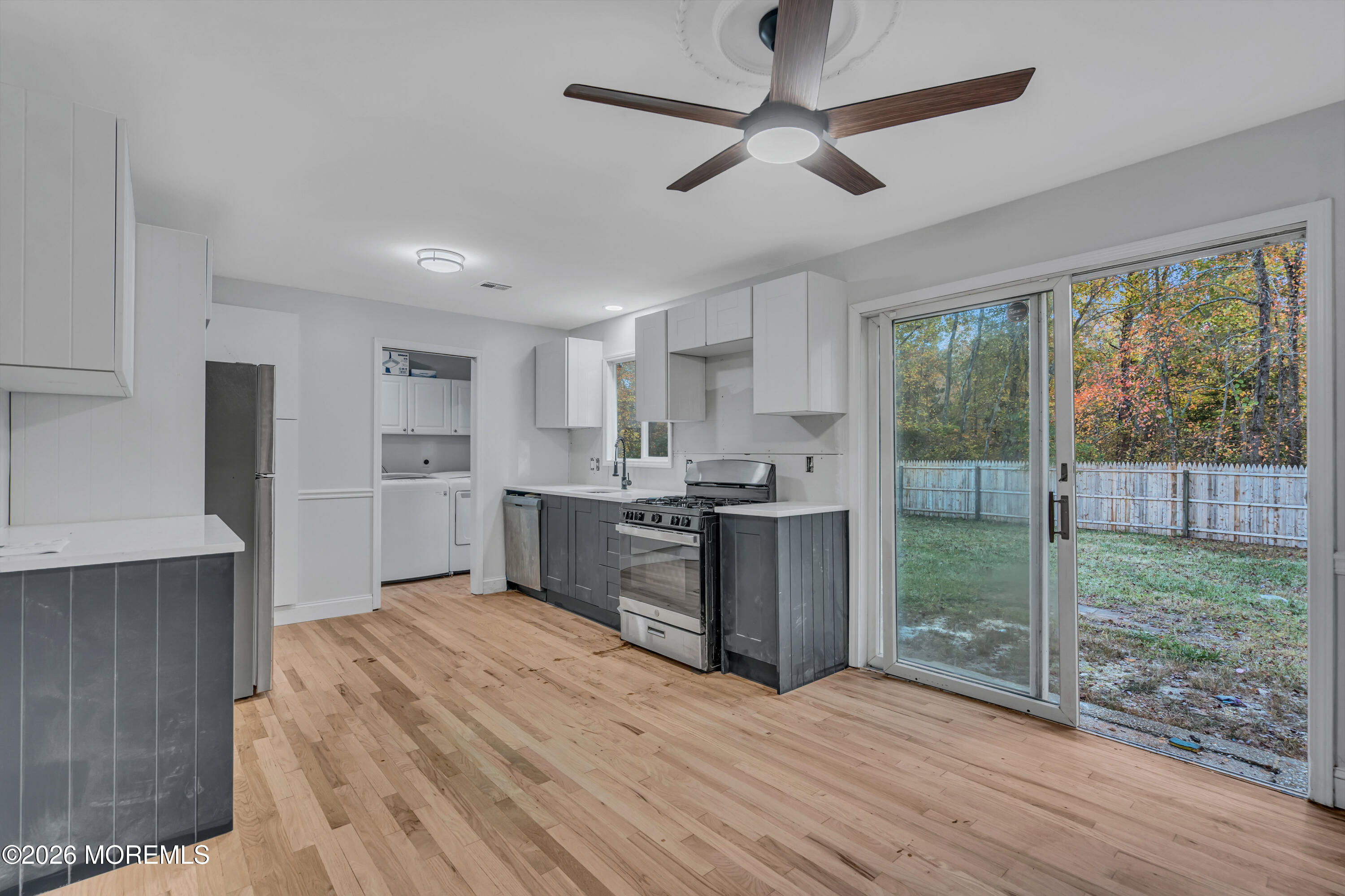 20 Jeanette Street Bayville, NJ 08721 - Photo 10 of 28 a kitchen with stainless steel appliances granite countertop a refrigerator a sink dishwasher a stove and white countertops with wooden floor