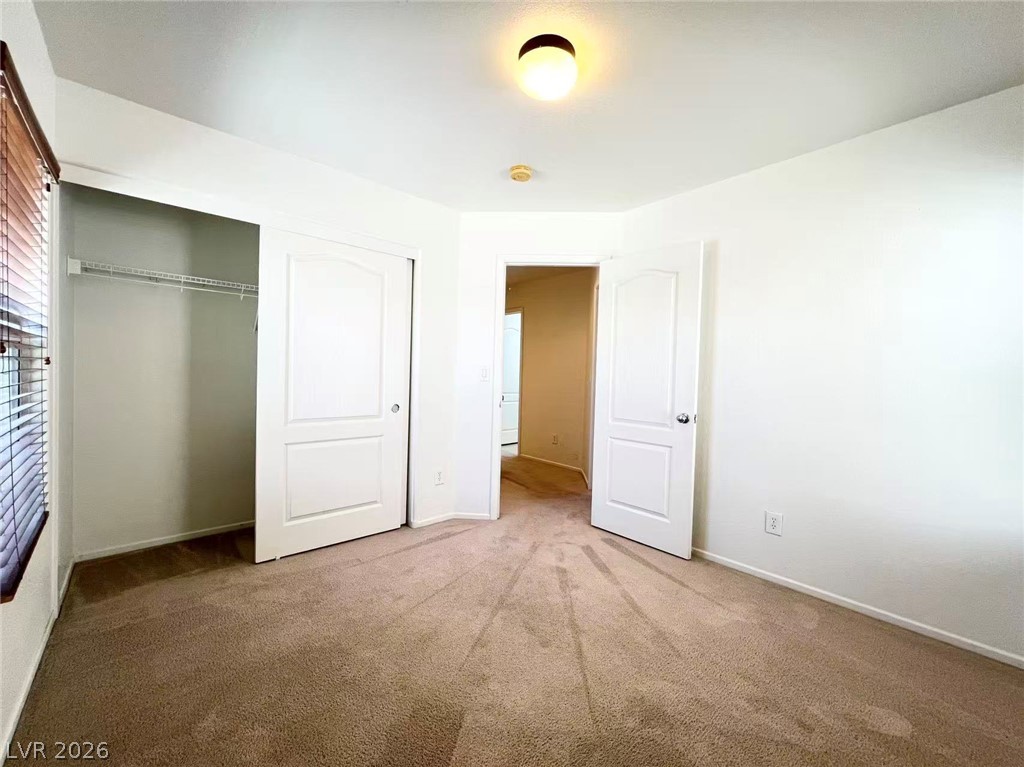 11143 Ranch Valley Street Las Vegas, NV 89179 - Photo 22 of 23 Comfortable carpeted bedroom with a built-in closet and easy access to other areas of the home.