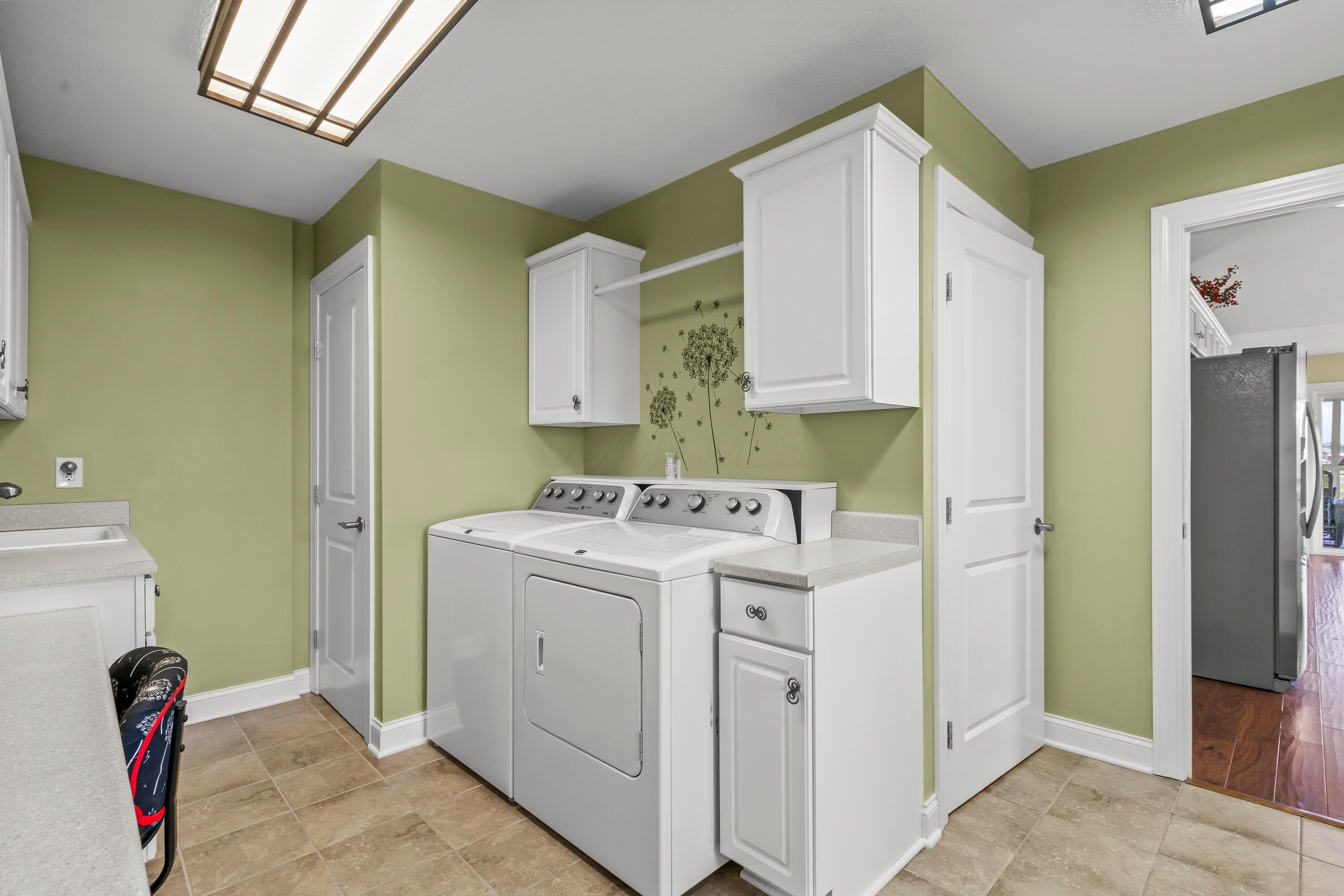 3582 Panhandle Road Delaware, OH 43015 - Photo 32 of 65 • Ceramic tile flooring • Lime painted walls • Ceiling light • Wall cabinets • Planning desk • Electric dryer hookup • Washer & dryer remain • Enclosed utility sink • Step-in closet with pegboard walls • Built-in bench with seating remains • Built-in ironing board • Lighted pantry with (2) doors