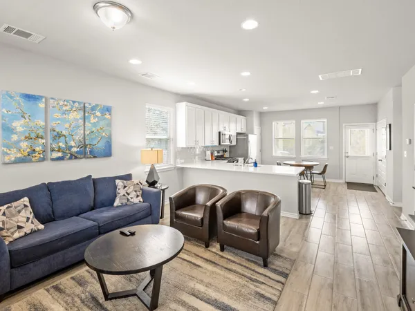 a living room kitchen with furniture and a wooden floor