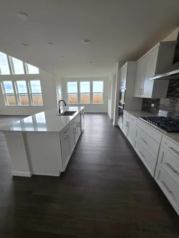 a large kitchen with counter top space and stainless steel appliances