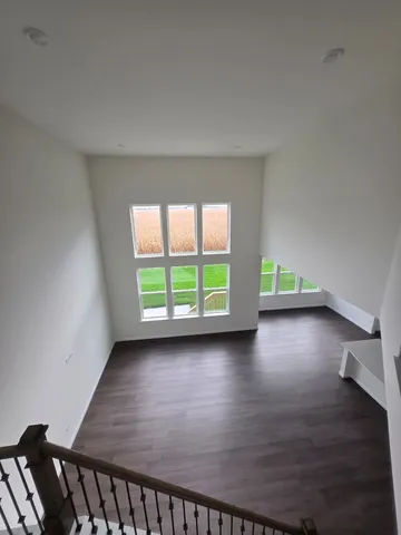 a view of a room with wooden floor and a window