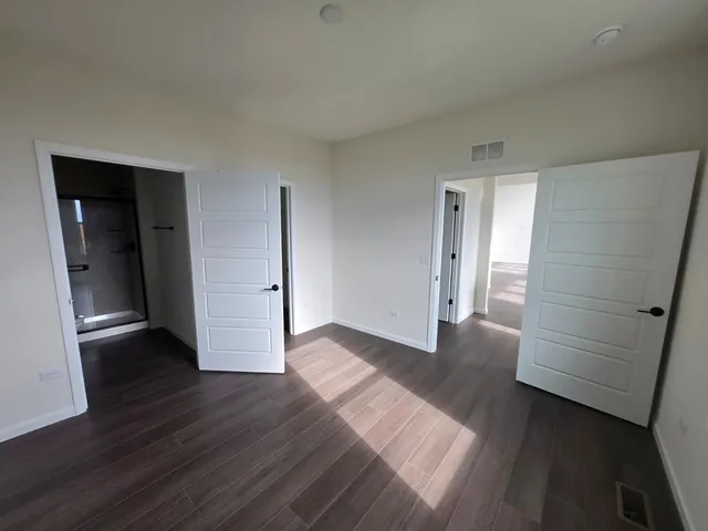 an empty room with wooden floor and closet
