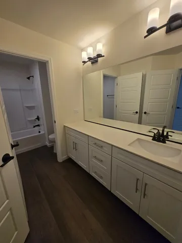 a spacious bathroom with a double vanity sink a mirror and a shower