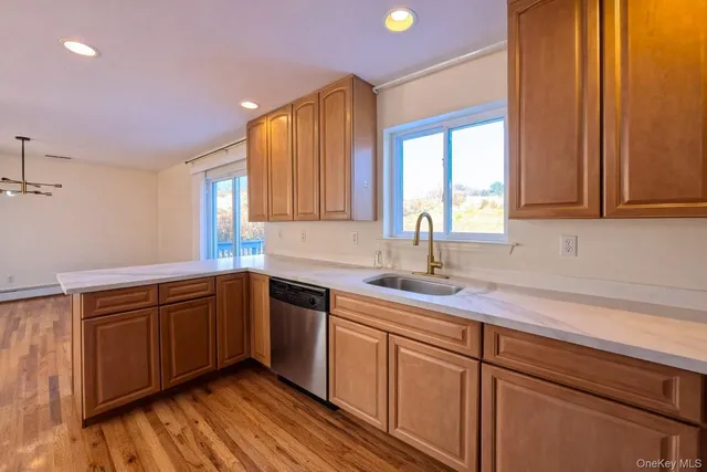 a kitchen with stainless steel appliances granite countertop wooden cabinets a sink and dishwasher next to a window