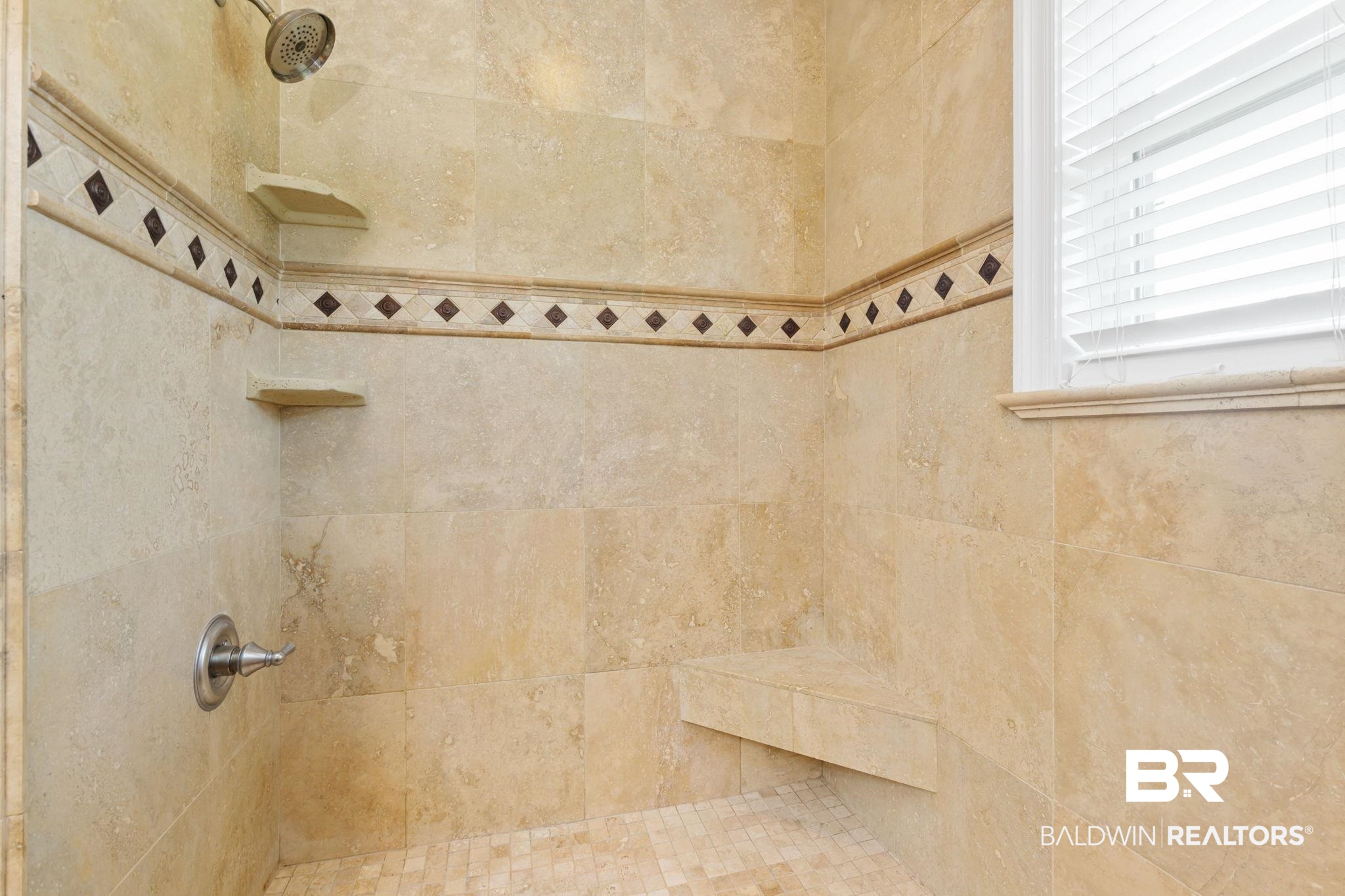 7540 2 Mile Road Irvington, AL 36544 - Photo 51 of 82 Tiled shower featuring a built-in bench, corner shelving, and a decorative accent band