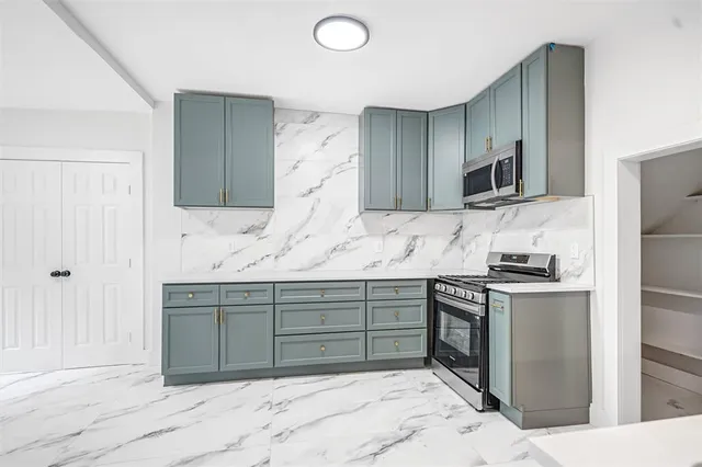 a kitchen with stainless steel appliances granite countertop a sink and a stove