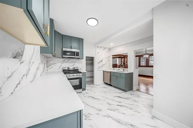 a kitchen with stainless steel appliances a microwave a stove and a refrigerator