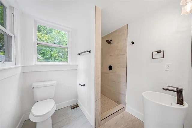 a bathroom with a toilet and a shower