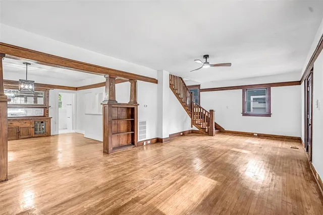 a view of a livingroom with wooden floor and a ceiling fan