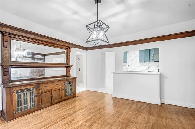 a view of a hallway with wooden floor and a chandelier