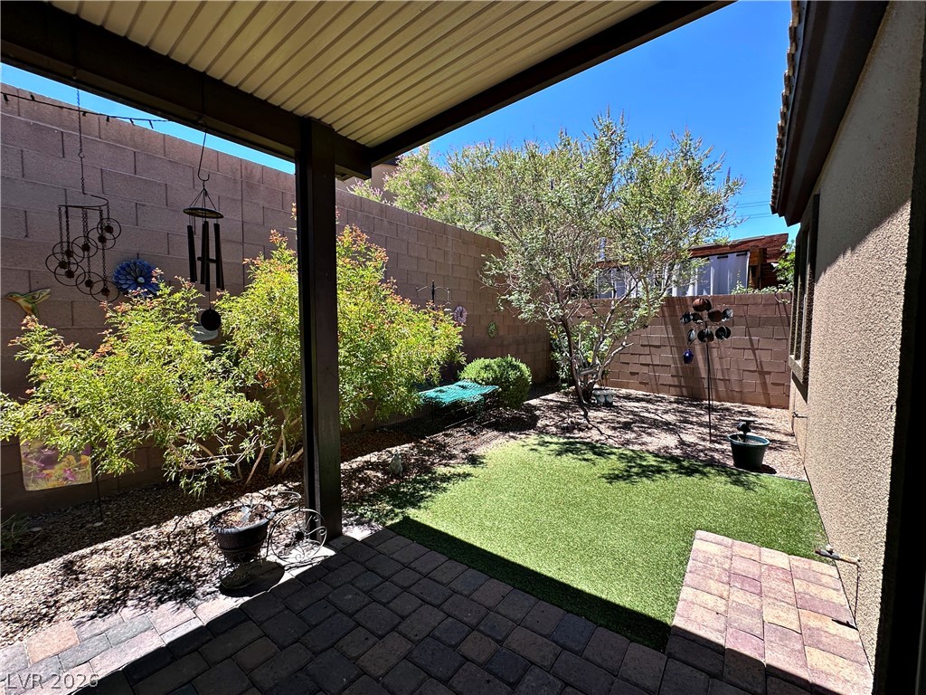 71 Newton Ridge Way Las Vegas, NV 89183 - Photo 34 of 40 A private outdoor space features a combination of pavers, turf, and lush greenery.
