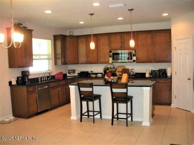 46 Molasses Court Fruit Cove, FL 32259 - Photo 3 of 17 a kitchen with granite countertop a stove a sink a dining table and chairs