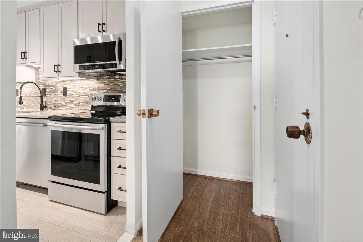 9701 Fields Road, Unit 1408 Gaithersburg, MD 20878 - Photo 9 of 29 a kitchen with stainless steel appliances granite countertop a stove microwave and refrigerator