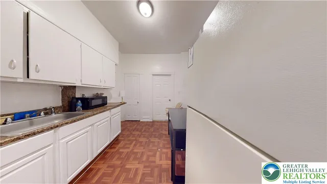 a kitchen with granite countertop white cabinets and white appliances