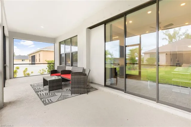 a living room with furniture and floor to ceiling windows