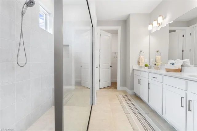a bathroom with a double vanity sink mirror and shower
