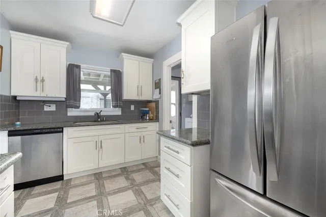 a kitchen with stainless steel appliances granite countertop a refrigerator and a stove