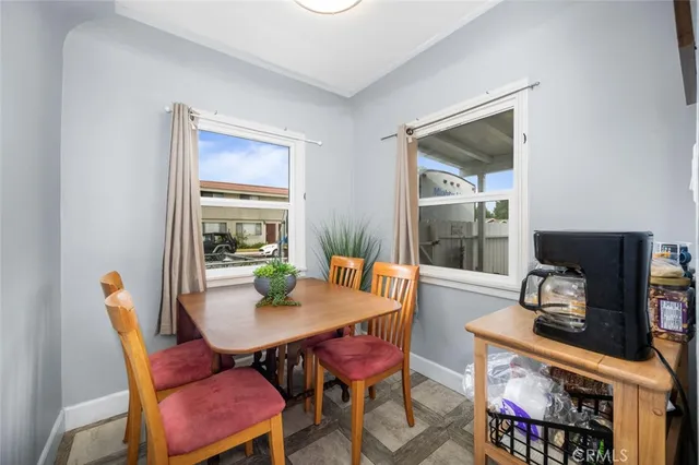 a dining room with furniture a rug and a floor to ceiling window