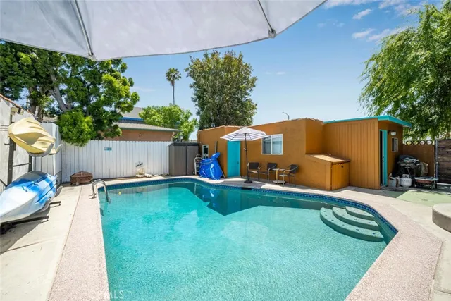 a backyard of a house with table and chairs a barbeque