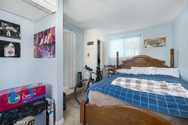 a bedroom with a bed and a bathroom with a mirror