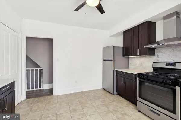 a kitchen with granite countertop a stove and a refrigerator with cabinets