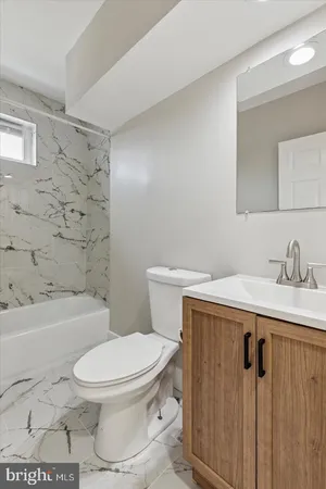 a white toilet sitting next to a bathroom sink and a shower