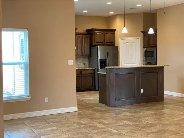 a view of kitchen with refrigerator and microwave
