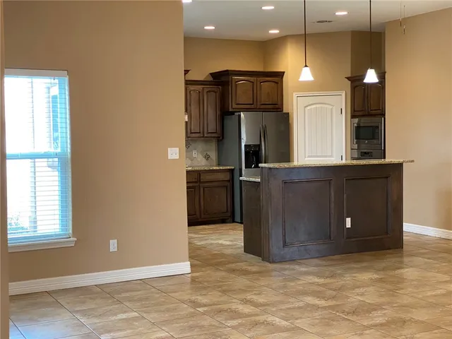 a view of kitchen with refrigerator and microwave