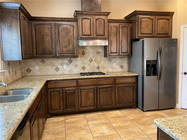 a kitchen with stainless steel appliances granite countertop a sink stove and refrigerator