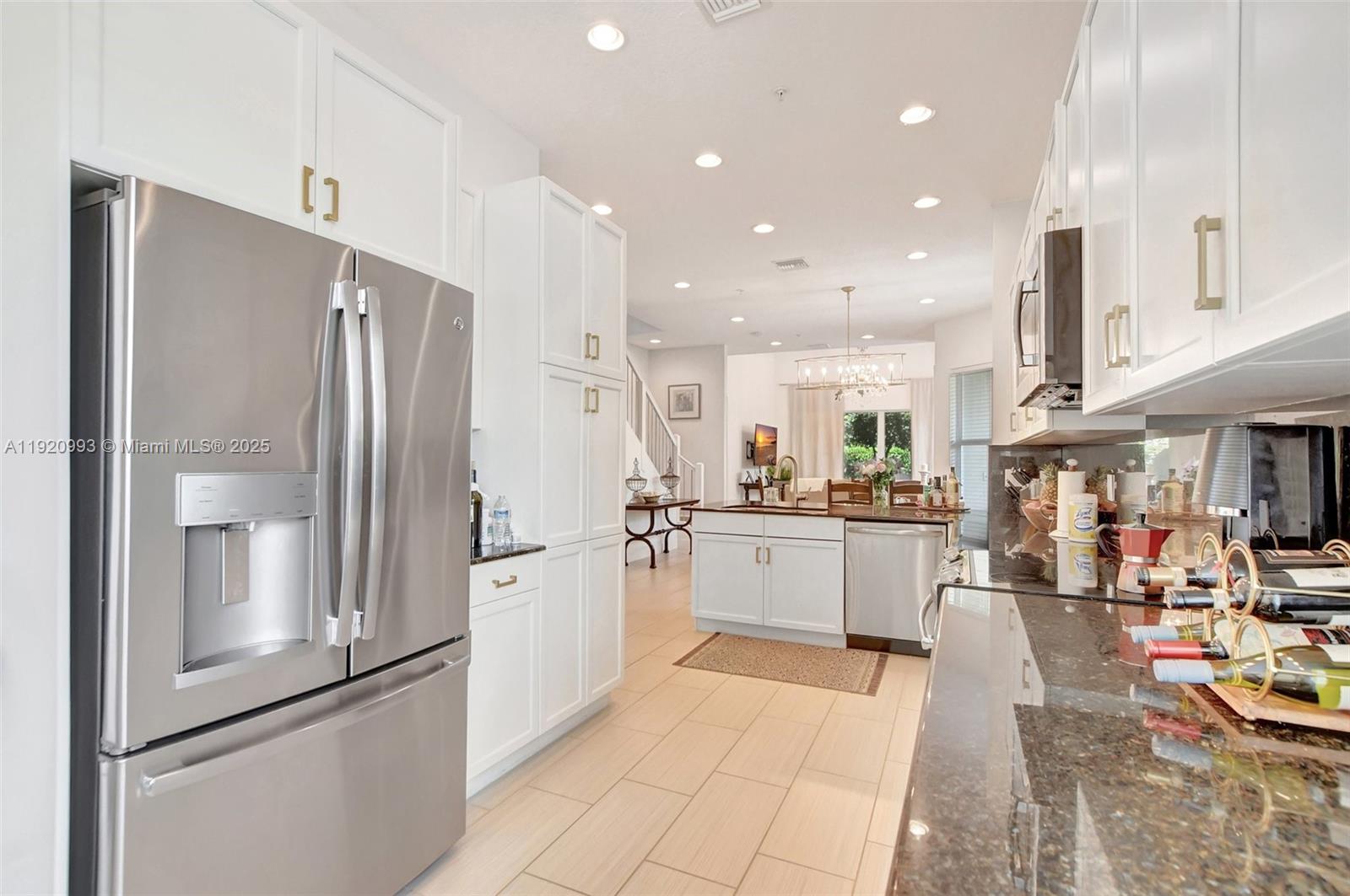 6657 Quiet Wave Trail, Unit 100 Boca Raton, FL 33433 - Photo 11 of 40 a kitchen with stainless steel appliances granite countertop a refrigerator and a sink