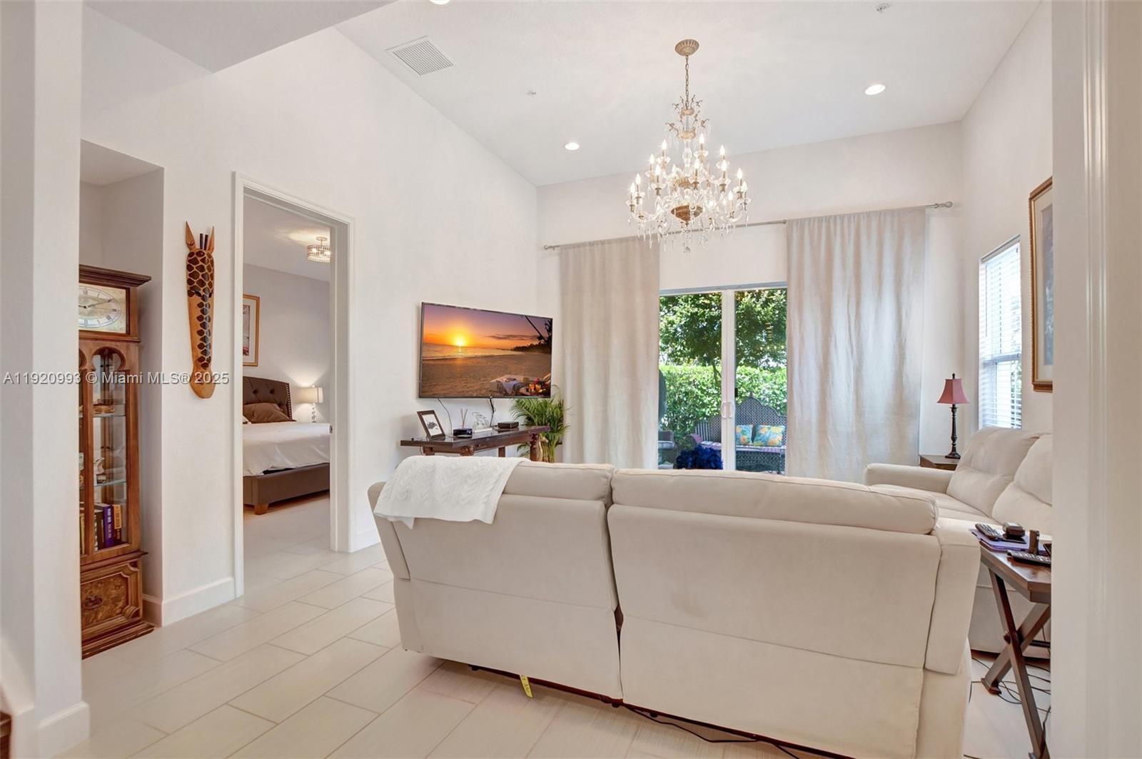 6657 Quiet Wave Trail, Unit 100 Boca Raton, FL 33433 - Photo 12 of 40 a living room with furniture a fireplace and a flat screen tv