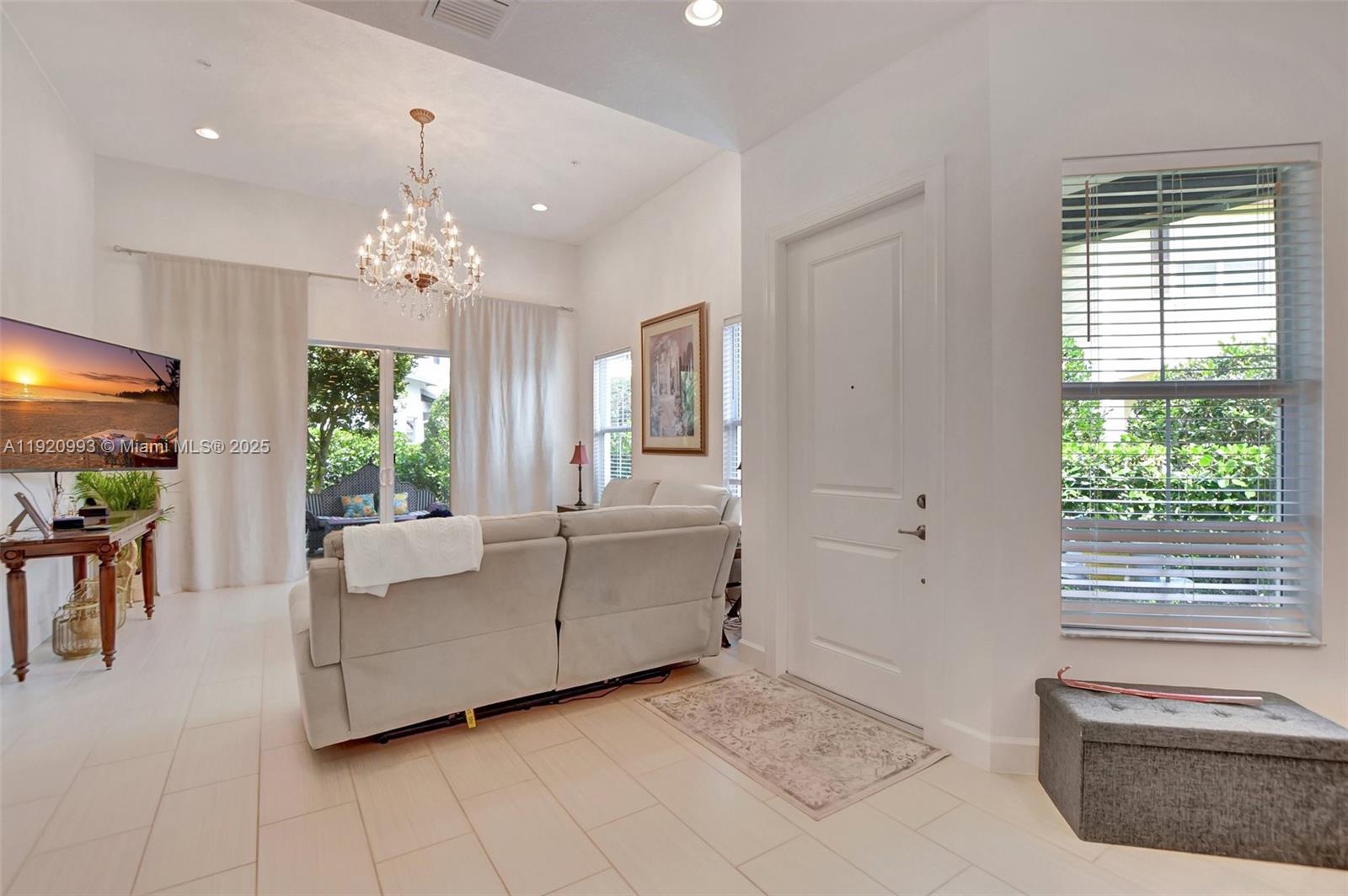 6657 Quiet Wave Trail, Unit 100 Boca Raton, FL 33433 - Photo 14 of 40 a living room with furniture and a chandelier