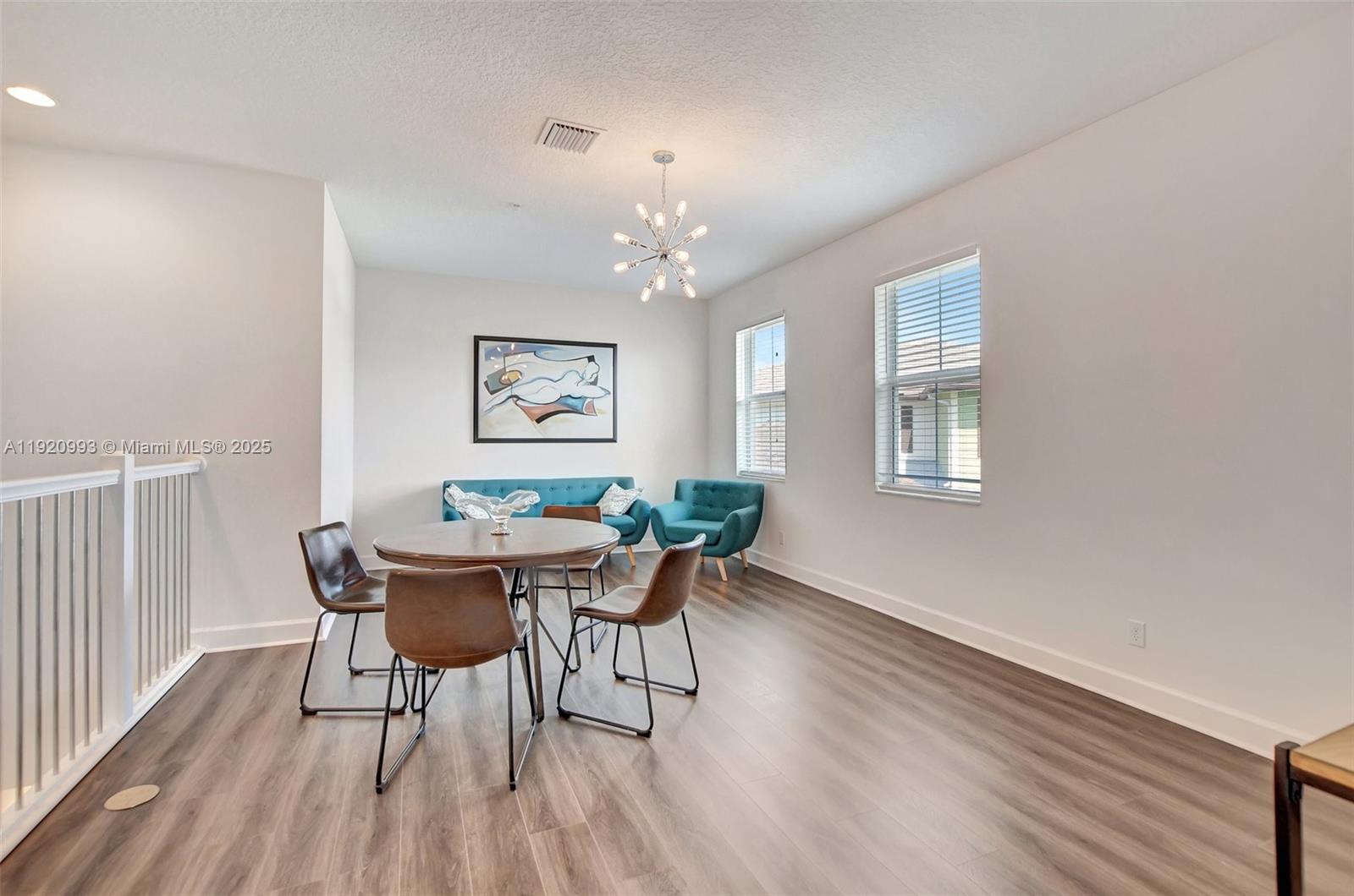 6657 Quiet Wave Trail, Unit 100 Boca Raton, FL 33433 - Photo 17 of 40 a dining room with furniture a chandelier and wooden floor