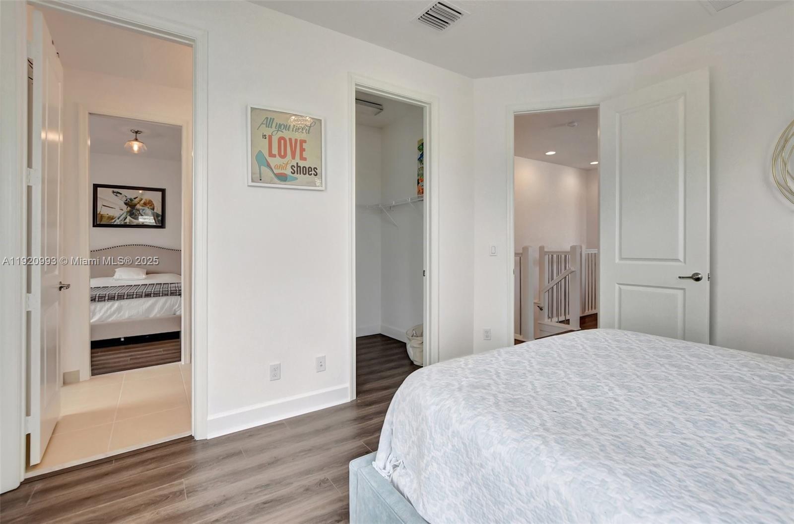 6657 Quiet Wave Trail, Unit 100 Boca Raton, FL 33433 - Photo 24 of 40 a bedroom with a bed and a view of bathroom