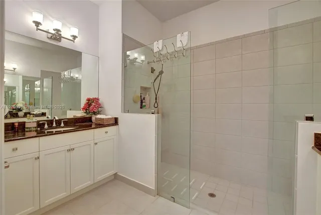 a bathroom with a granite countertop sink a mirror and a shower