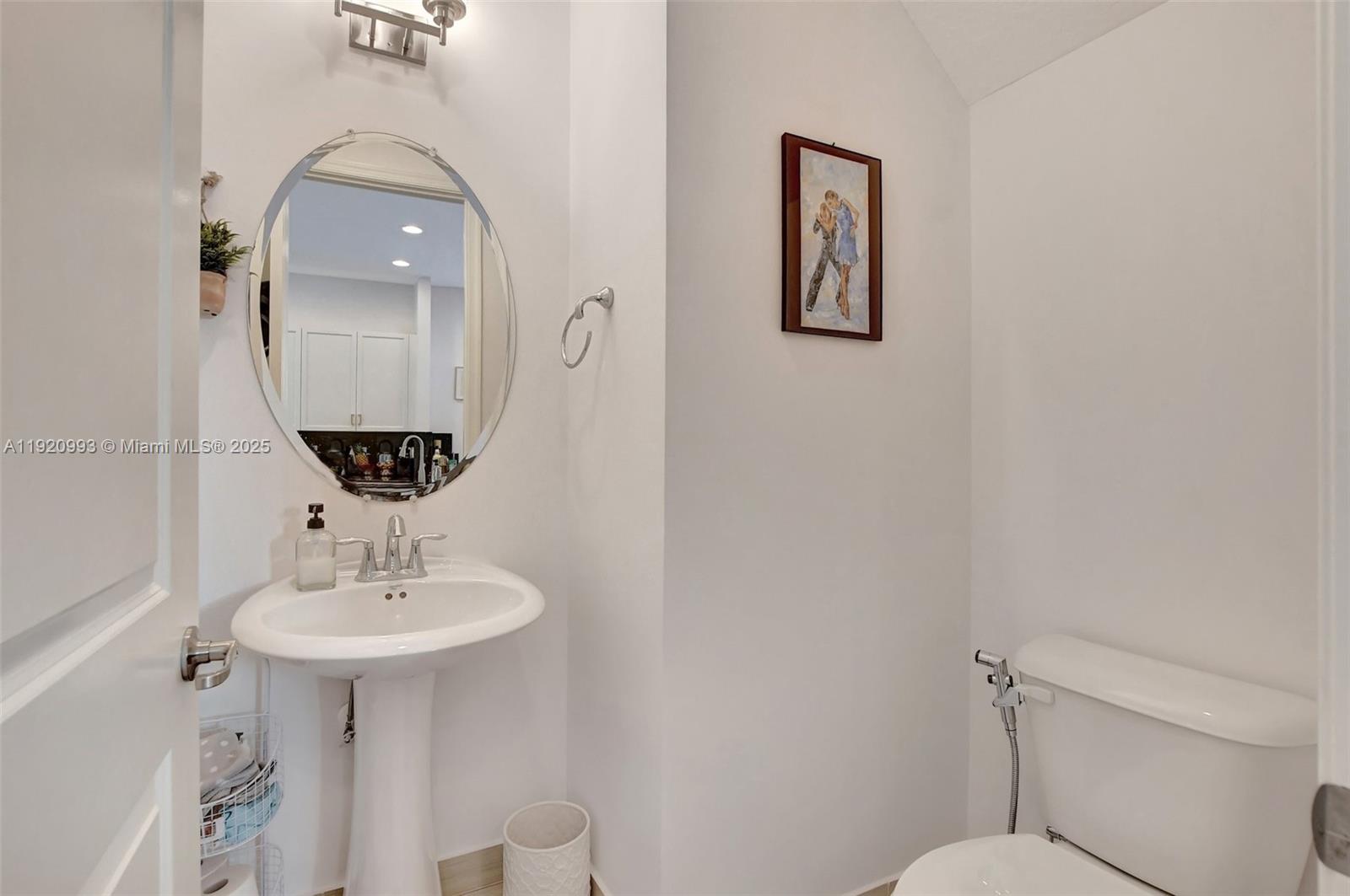 6657 Quiet Wave Trail, Unit 100 Boca Raton, FL 33433 - Photo 34 of 40 a bathroom with a toilet sink and mirror